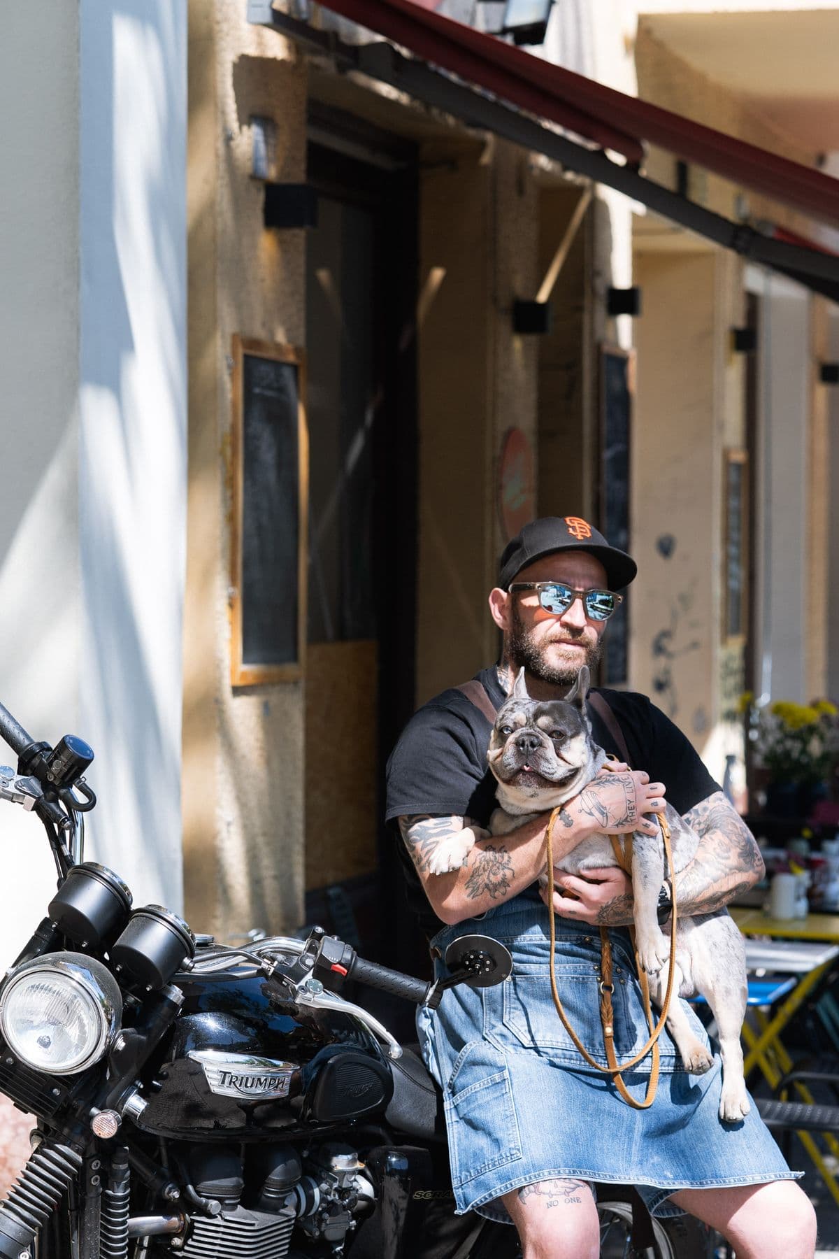 Alessandro und Fred auf dem Motorrad unter der roten Markise