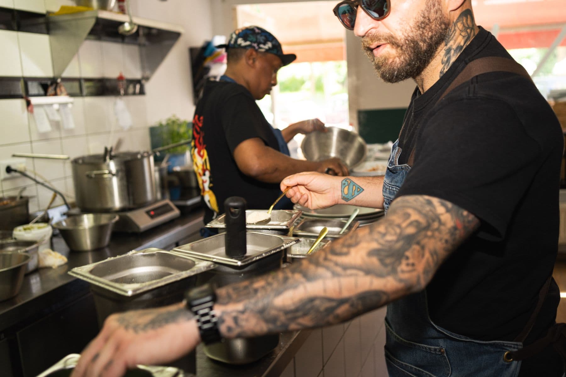 Zwei Köche arbeiten nebeneinander in der offenen Küche