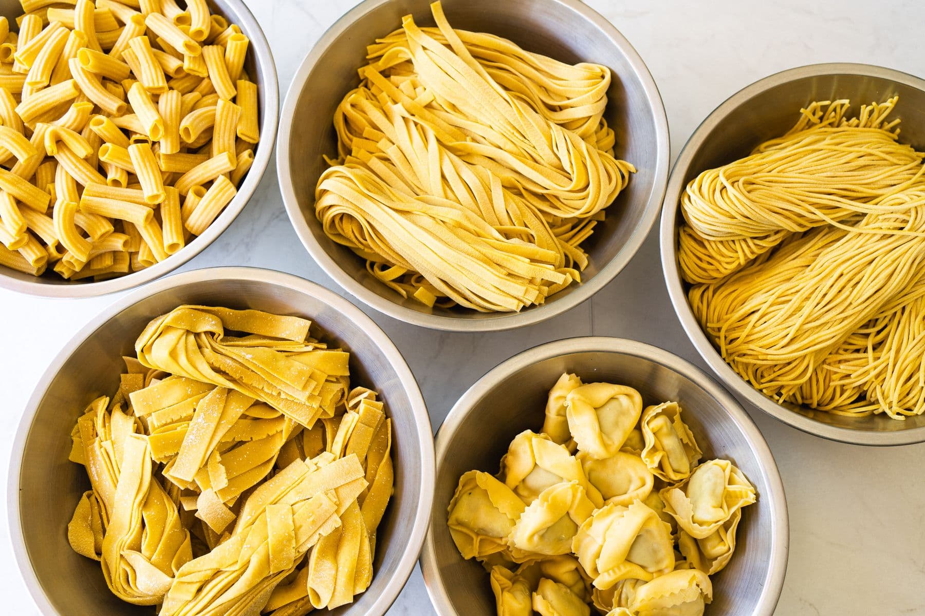 Fünf Schüsseln frische Pasta: Rigatoni, Tagliatelle, Tagliolini, Pappardelle, Tortelloni